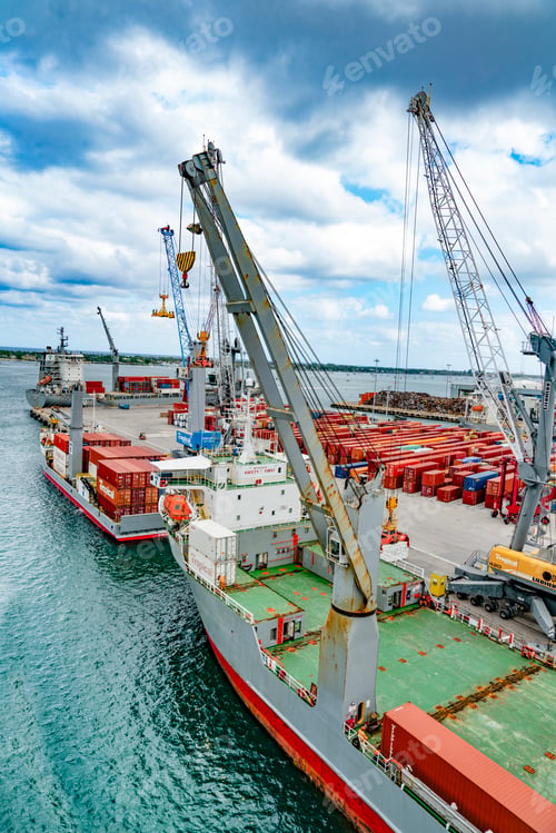 Preview: Containers loading on to a cargo ship on a bright sunny day