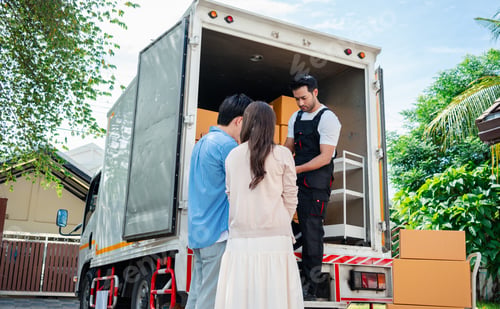 Preview: Asian Couple check while unloading boxes and furniture from a pickup truck to a new house with servi