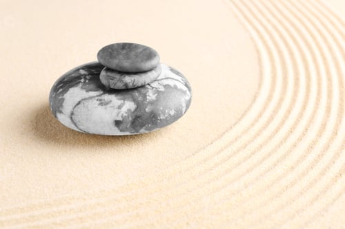 Preview: Zen garden stones on beige sand with pattern. Space for text