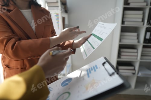 Preview: Business professionals working together at office desk, hands close up pointing out financial data