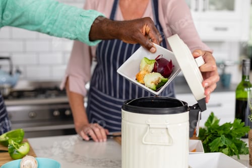 Preview: Midsection of senior multiracial couple preparing food in kitchen at home