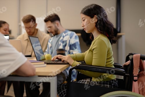 Preview: Young Female Student with Disability Studying at Desk