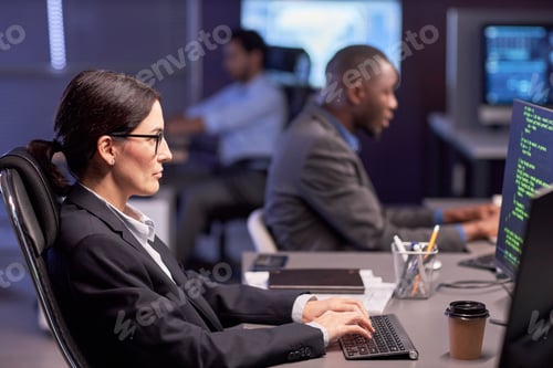 Preview: Serious businesswoman using computer at workplace in IT office