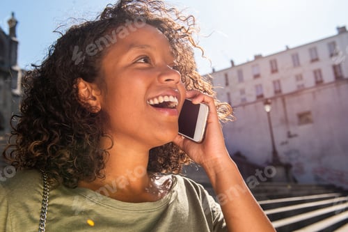 Preview: Close up happy young woman talking with cellphone in city