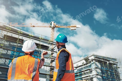Preview: Shot of a young man and woman assessing progress of the building at a construction site