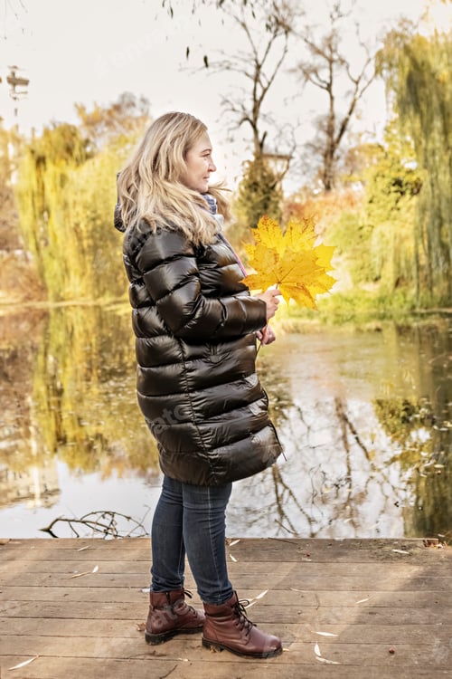 Preview: Portrait of a woman on the shore of a pond in an autumn park