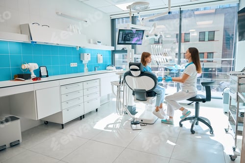 Preview: Dentist communicates with a young patient in a dental office