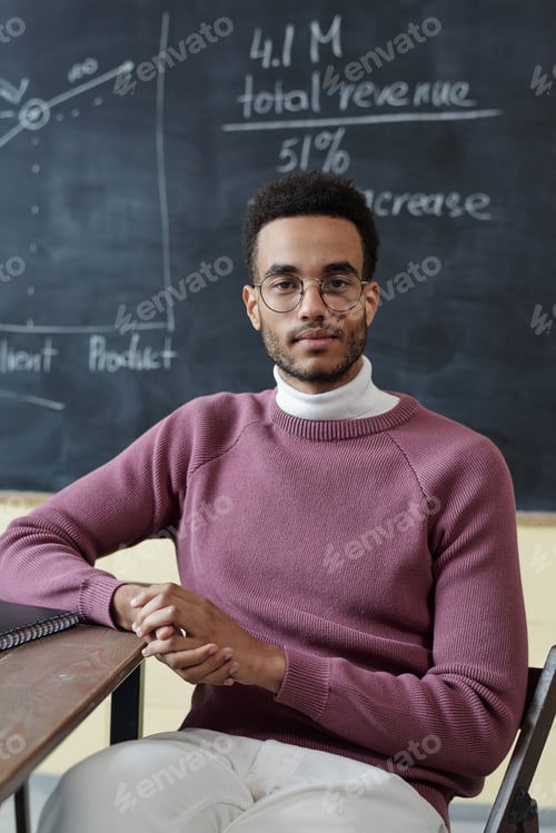 Preview: Young contemporary businessman or student sitting by table