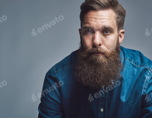 Preview: Close up on serious man in blue shirt and beard