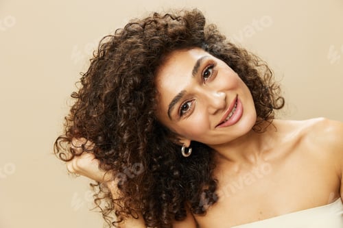 Preview: Woman applies cream and balm to her curly hair, the concept of protection and care, a healthy look