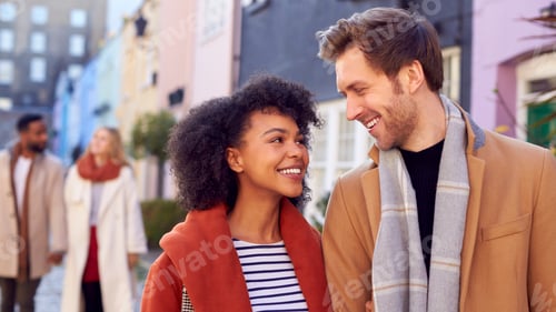 Preview: Multi Cultural Couple With Friends Walking Along Residential City Street In Fall Or Winter