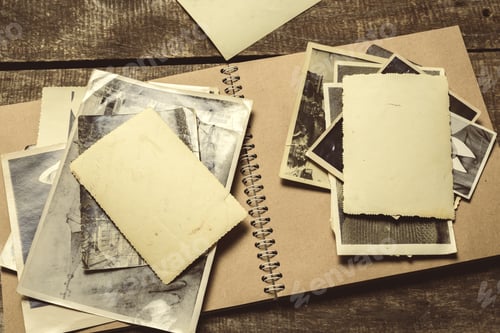 Preview: Old photographs and empty spaces on a notepad in a simple setting with wooden surface