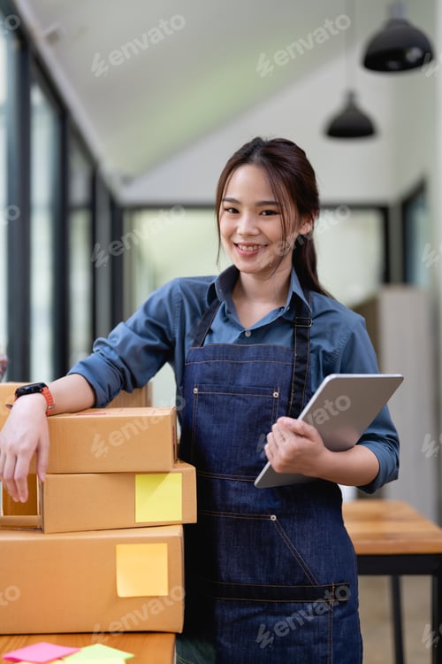 Preview: Portrait of Asian young woman SME working with a box at home the workplace.start-up small business