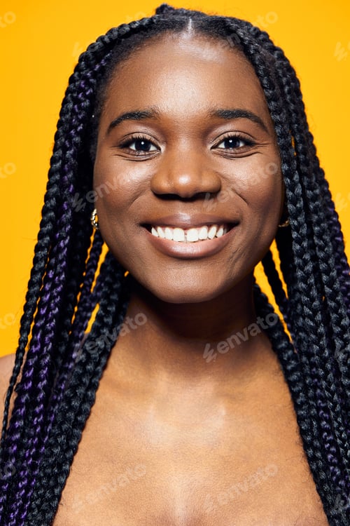 Preview: Cheerful female model with braided hair and a bright smile against a yellow background, representing