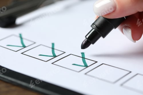 Preview: Woman checking box of paper form at wooden table, closeup