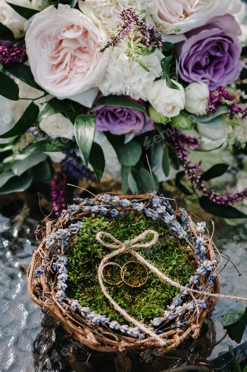 Preview: Bride and groom rings. The bride's bouquet. Two wedding rings decorated lavender. Top view.