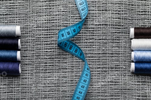 Preview: top view of blue and grey thread coils with measuring tape on sackcloth