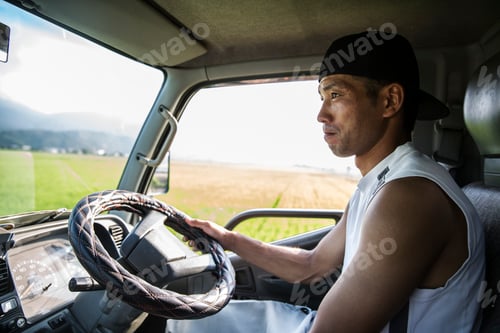 Preview: Portrait of Japanese farmer sitting in his tractor.