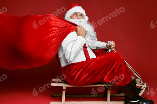 Preview: Caucasian Santa Claus with sack of Christmas Presents go of sledge