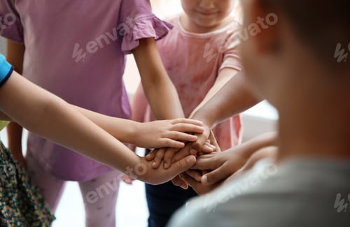 Preview: Little children putting their hands together, closeup. Unity concept