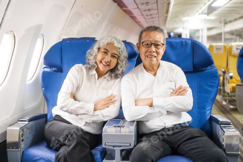 Preview: A mature couple enjoys a plane ride, seated near the window. They gaze out at the sky, savoring