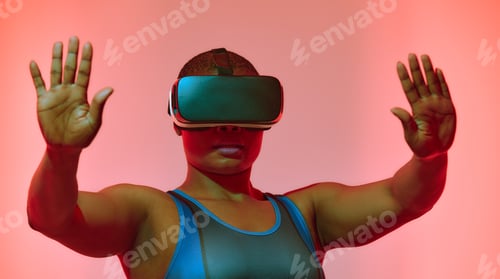 Preview: African american woman streamer playing video game using virtual reality glasses at gaming room