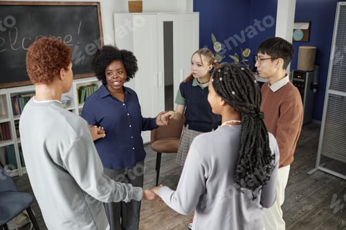 Preview: Group of Teenagers Standing in Circle Holding Hands in Group Therapy
