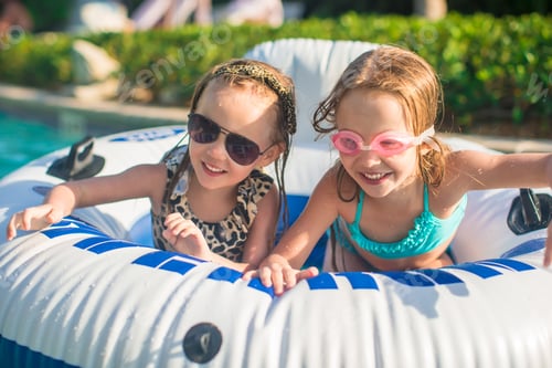Preview: Little adorable girls swimming in the swimmingpool
