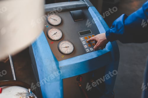 Preview: Auto mechanic presses a button on the machine to refuel air conditioners in the car