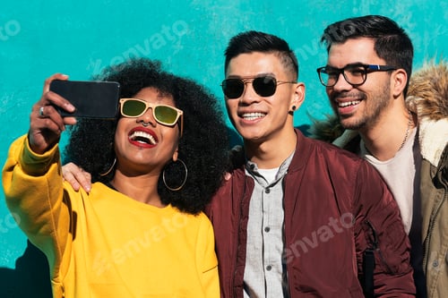 Preview: Group of happy friends taking a selfie in the street.