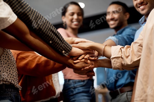 Preview: Shot of a group of businesspeople joining hands in solidarity in a modern office