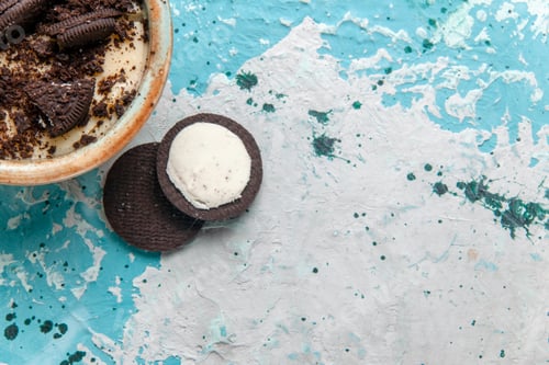 Preview: top view chocolate cookie dessert with cream and cookies inside plate on the light blue background