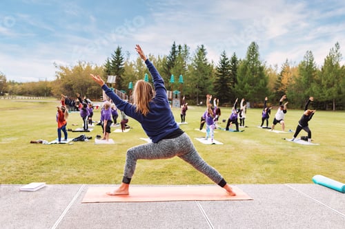 Preview: Outdoor Yoga classes. Group of adults attending yoga classes in the park.