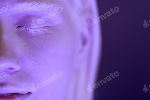 Preview: Woman with Albinism Standing with Eyes Closed in Ultraviolet Neon Light