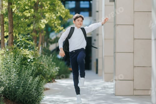 Preview: Front View of Excited Schoolboy Jumping Happily on the Way to School