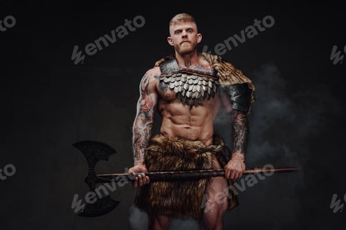 Preview: Brutal tattooed warrior wearing light armour and fur holding two-handed axe in dark studio