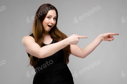 Preview: Half-length portrait of smiling young brunette girl in black dress on gray background
