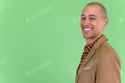 Preview: Closeup profile view of happy bald multi ethnic businessman looking at camera
