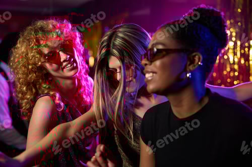 Preview: Cheerful women dancing together at disco party