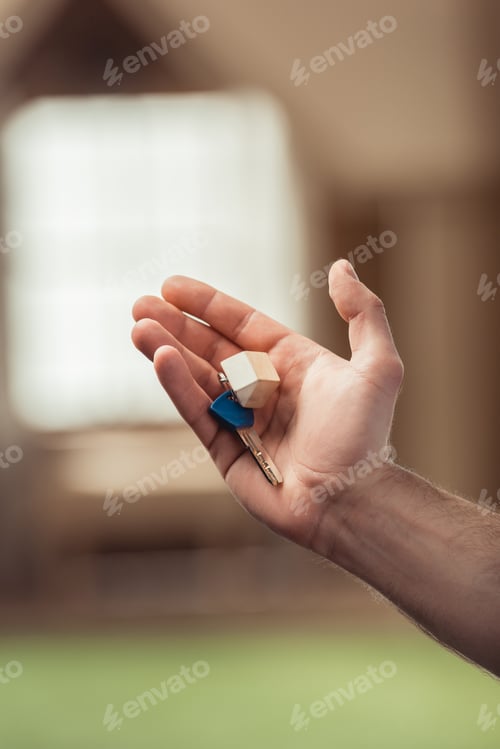 Preview: cropped shot of man holding key of new house
