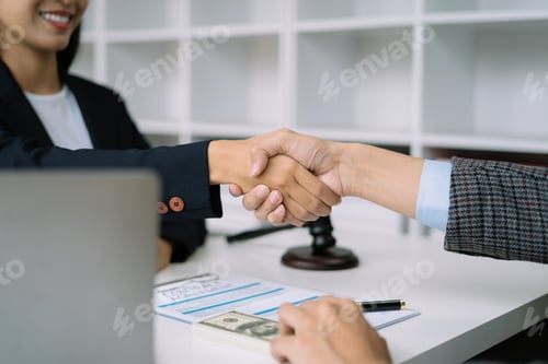 Preview: Lawyer shaking hands with client after discussing final contract agreement.