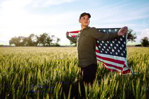 Preview: Man hold waving american USA flag. Patriot raise national american flag. Independence Day, 4th July.