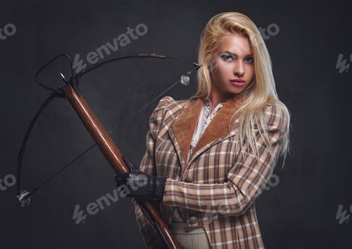 Preview: Studio portrait of blond old fashioned female holds a crossbow.