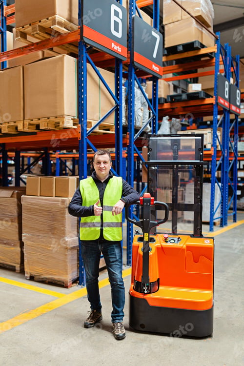 Preview: Worker in uniform standing on modern warehouse with shelves and reach truck