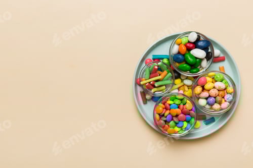 Preview: Multicolored candies in a bowl on a colored background. birthday and holiday concept