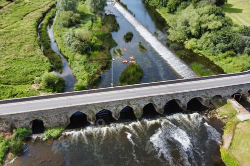 Preview: Aerial view of a bridge over a river, surrounded by trees