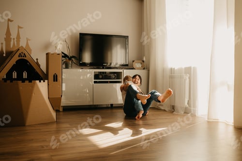 Preview: Smiling Woman Playing With a Baby Indoors