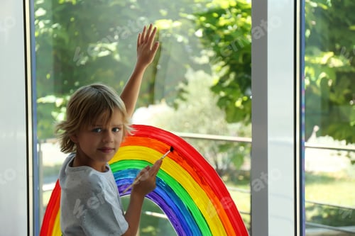 Preview: Little boy drawing rainbow on window. Stay at home concept