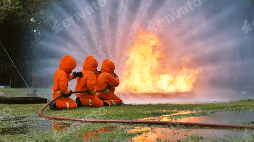 Preview: Firefighter fighting with flame using fire hose chemical water foam spray engine. Fireman hard hat