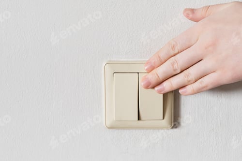 Preview: Hand turning off light switch on white wall, saving electricity